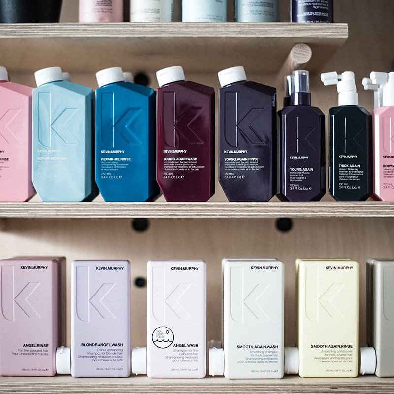 Close up of Kevin Murphy branded hair products on a wooden shelf