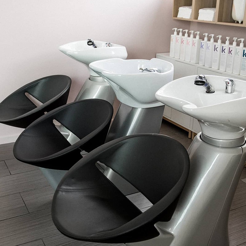 Interior view of Violet Hair Lounge focused on the hair wash station chairs and basins